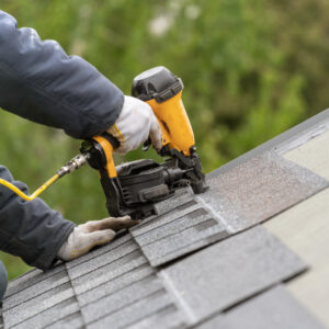 roofing contractor installs shingles for a roof repair job